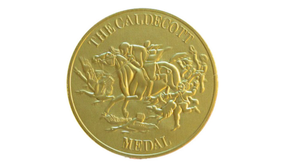 Gold stamp featuring a man riding a horse and text The Caldecott Medal
