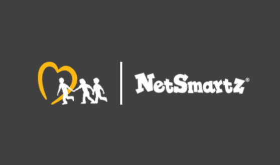 Logo on a dark gray background with a yellow heart symbol, two white silhouettes of children holding hands, and the text "NetSmartz" in bold white font.