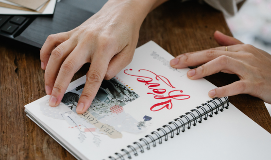 Person pasting a photo into a scrapbook