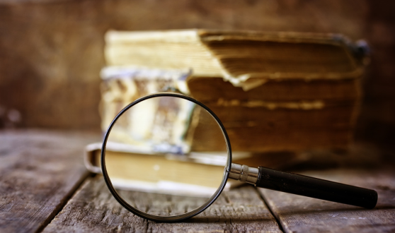 Magnifying glass in front of old books