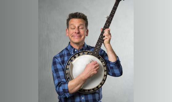 Man smiling holding a banjo