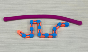 Fidget toys, one purple stretchy tube and one blue and orange clicker fidget